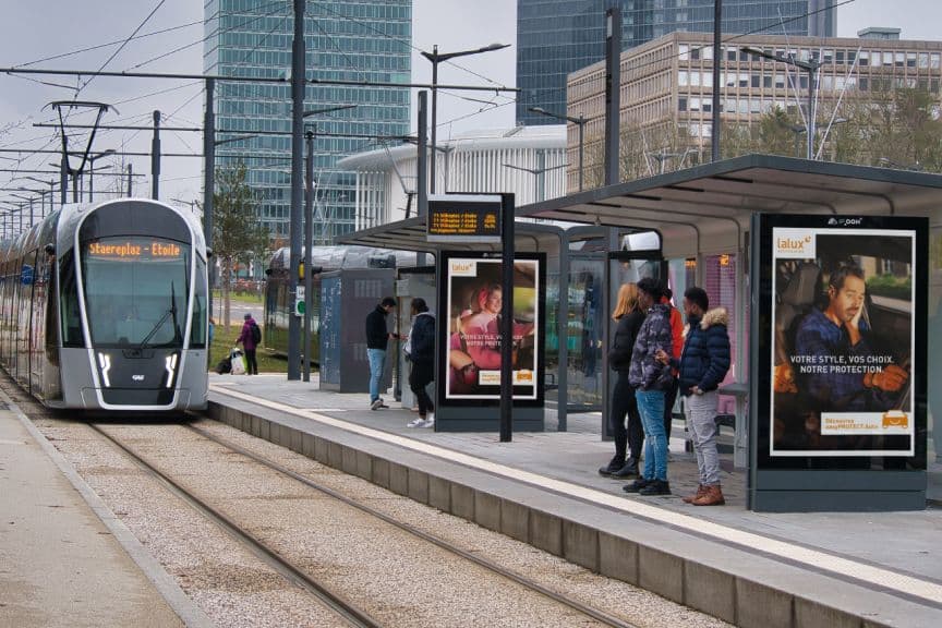 Station de tramway avec les visuels de campagnes auto sur les panneaux publicitaires